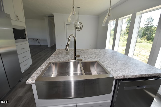 kitchen featuring dishwasher, a kitchen island with sink, sink, hanging light fixtures, and white cabinetry