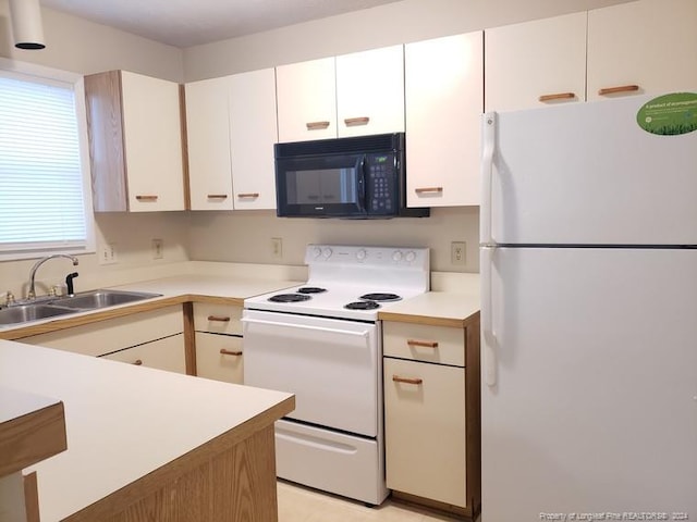 kitchen with white appliances, white cabinetry, and sink