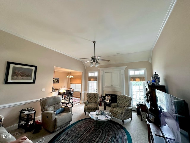 carpeted living room featuring ornamental molding, vaulted ceiling, and ceiling fan with notable chandelier