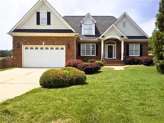 view of front of property with a garage and a front lawn