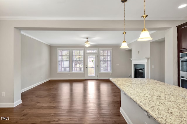 kitchen with pendant lighting, light stone counters, dark hardwood / wood-style flooring, and crown molding