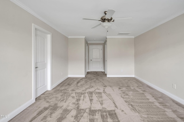 empty room with crown molding, light colored carpet, and ceiling fan