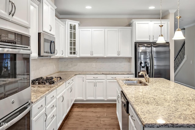 kitchen with sink, decorative light fixtures, stainless steel appliances, and white cabinets