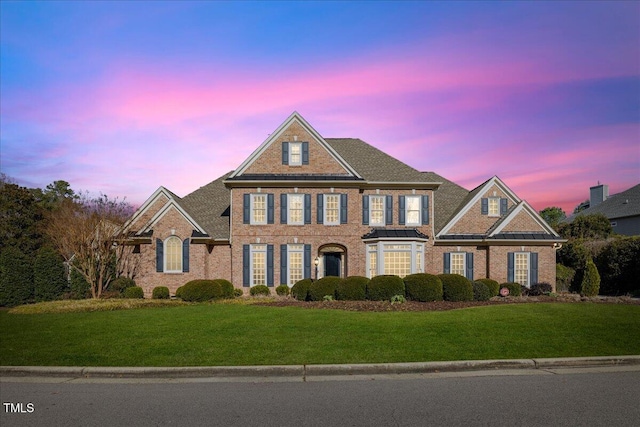 colonial inspired home with a lawn