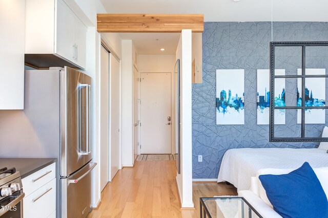 bedroom with tile walls and light hardwood / wood-style floors