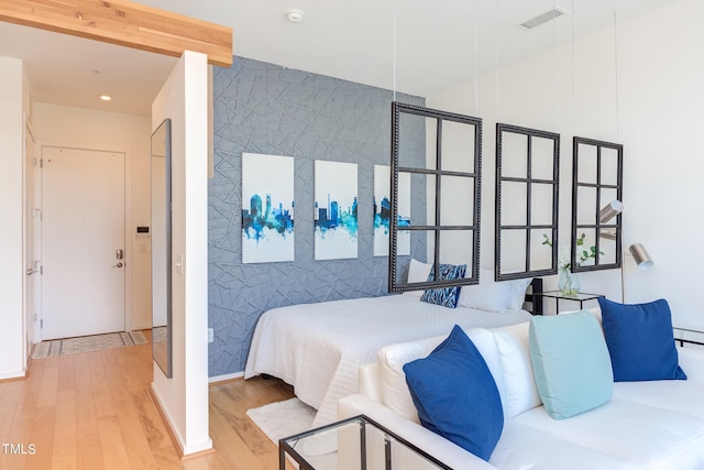 bedroom featuring light wood-type flooring and tile walls