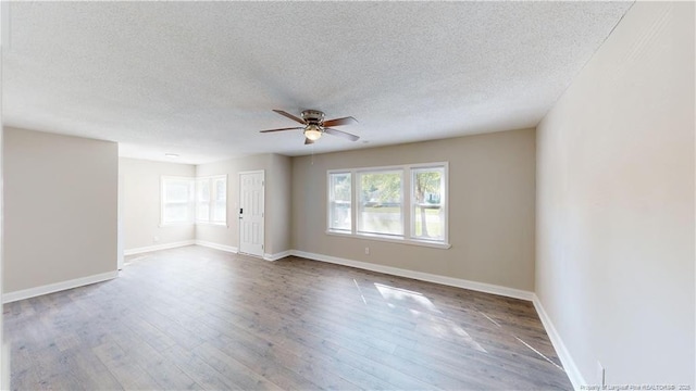 empty room featuring hardwood / wood-style flooring, ceiling fan, and a textured ceiling