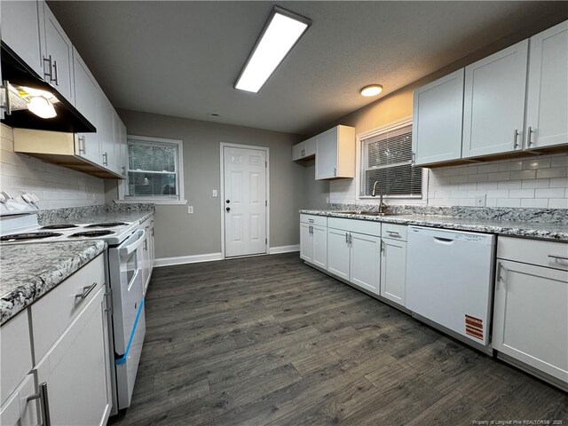 kitchen with sink, white appliances, white cabinetry, dark hardwood / wood-style floors, and light stone countertops