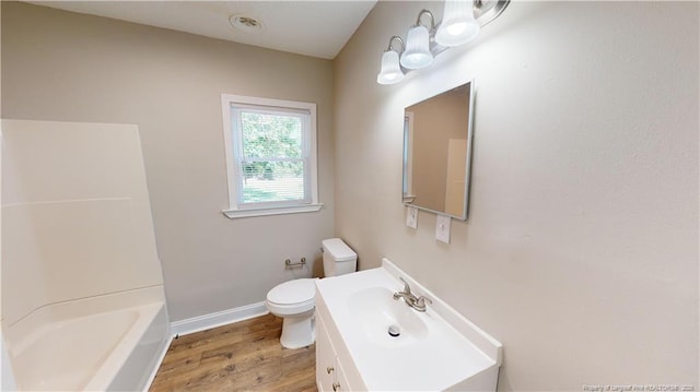 full bathroom featuring hardwood / wood-style flooring, vanity, shower / tub combination, and toilet