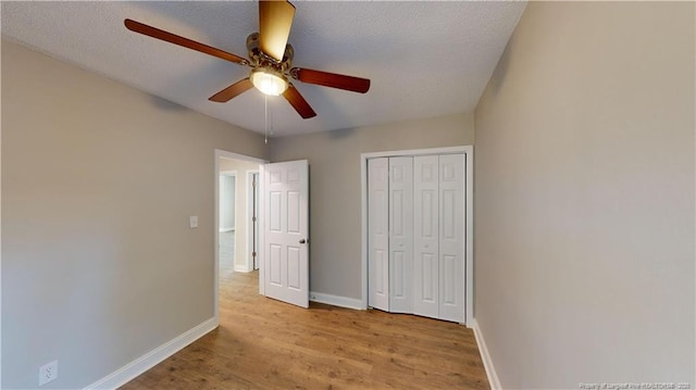 unfurnished bedroom featuring a closet, a textured ceiling, ceiling fan, and light hardwood / wood-style flooring