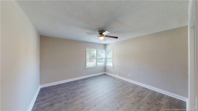 empty room featuring ceiling fan, dark hardwood / wood-style floors, and a textured ceiling