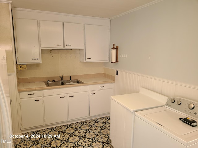 clothes washing area featuring cabinets and sink