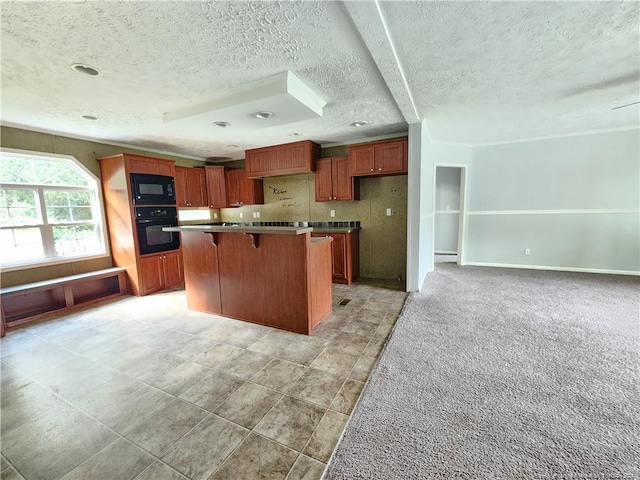 kitchen with a kitchen island, black appliances, tasteful backsplash, a breakfast bar area, and a textured ceiling