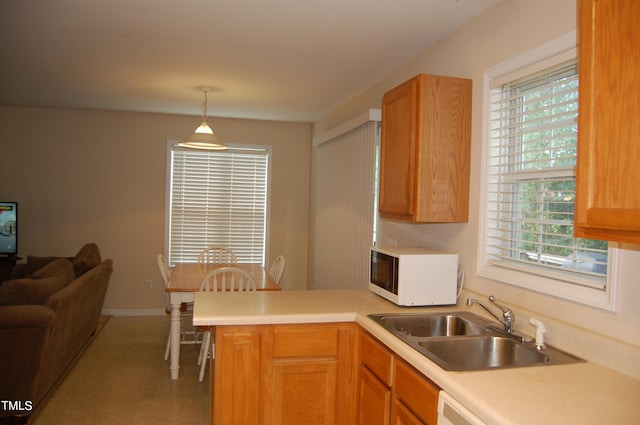 kitchen featuring pendant lighting, sink, and kitchen peninsula