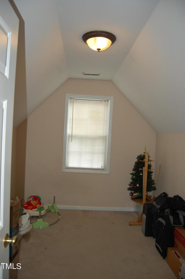 bonus room with lofted ceiling and carpet flooring