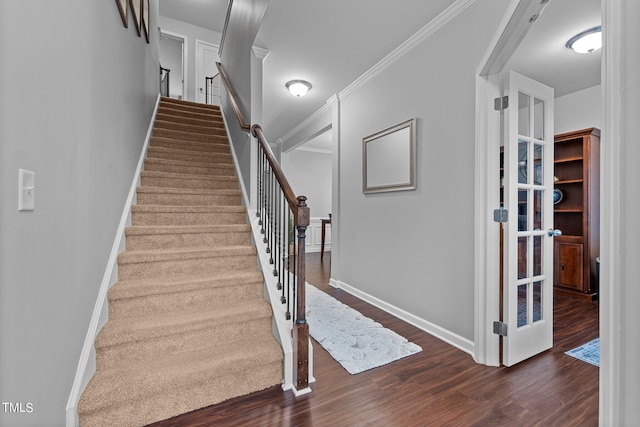 staircase with wood-type flooring and ornamental molding