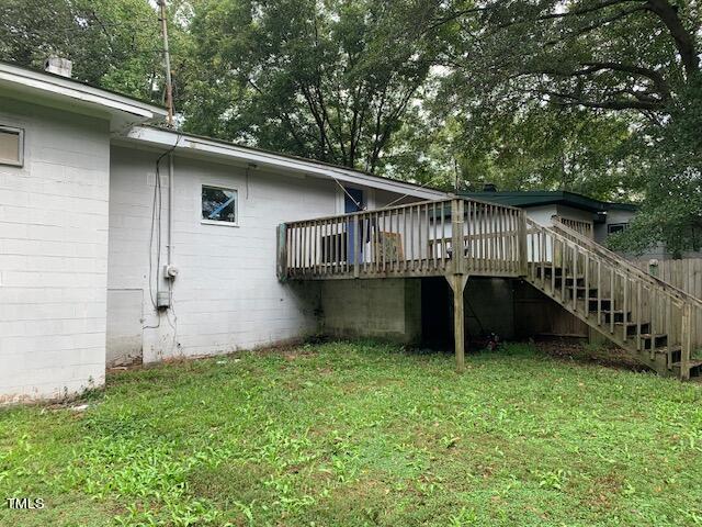 view of side of property with a wooden deck and a yard