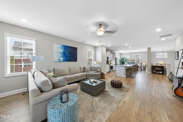 living room with ceiling fan and light hardwood / wood-style floors