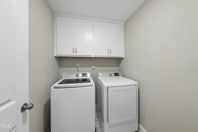 laundry area with washer and clothes dryer and cabinets