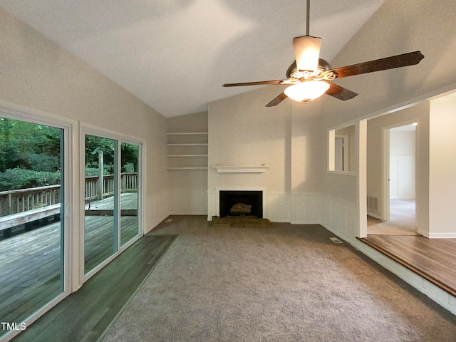 unfurnished living room featuring lofted ceiling, dark carpet, and ceiling fan