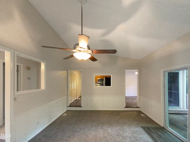 carpeted spare room with ceiling fan and vaulted ceiling