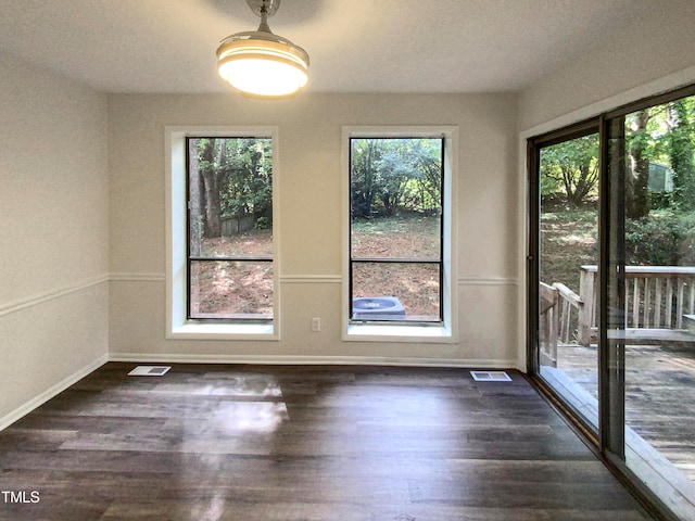 unfurnished dining area featuring dark hardwood / wood-style flooring