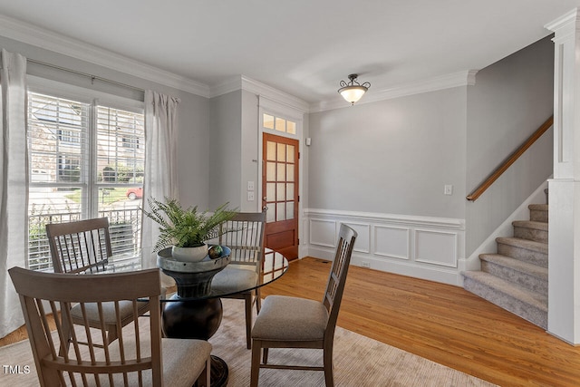 dining room with crown molding and light hardwood / wood-style floors