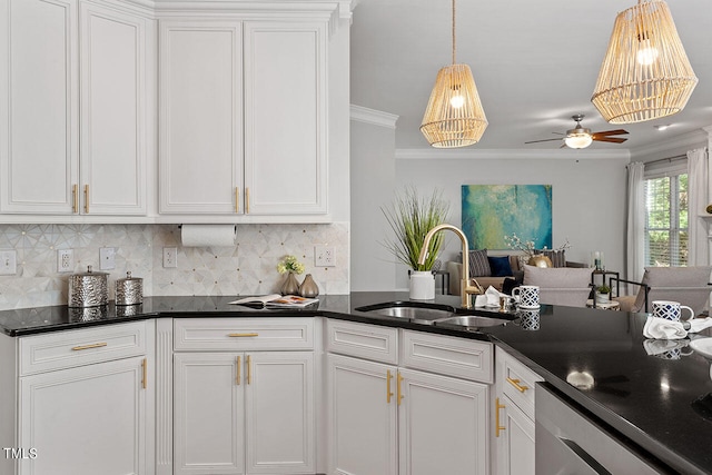 kitchen featuring white cabinets, backsplash, crown molding, and sink