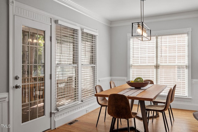 dining room with ornamental molding, light hardwood / wood-style floors, and a wealth of natural light