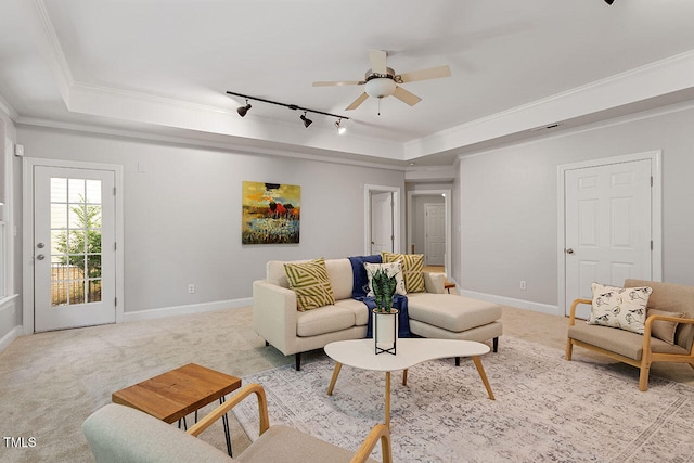 carpeted living room with ornamental molding, ceiling fan, a tray ceiling, and rail lighting