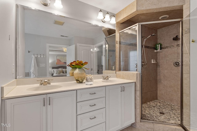 bathroom featuring tile patterned flooring, an enclosed shower, and vanity