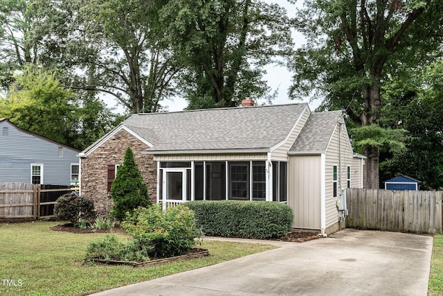 bungalow with a front lawn and a sunroom