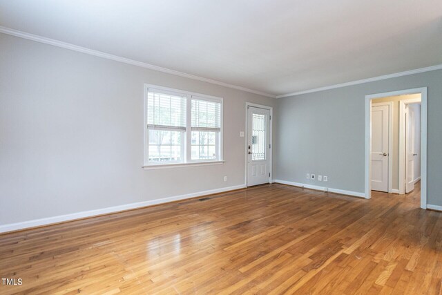 empty room with light wood-type flooring and ornamental molding