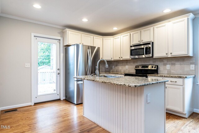 kitchen featuring a center island with sink, light wood-type flooring, sink, and appliances with stainless steel finishes