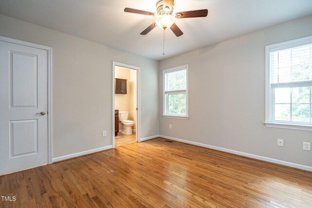 unfurnished bedroom with connected bathroom, light hardwood / wood-style flooring, and ceiling fan