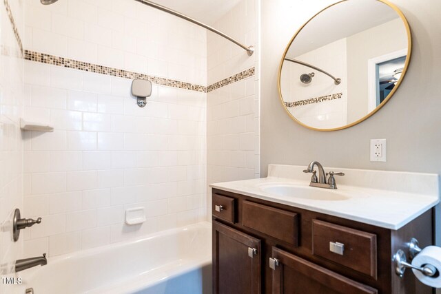 bathroom featuring vanity and tiled shower / bath