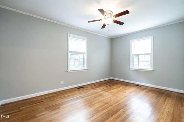 spare room featuring hardwood / wood-style flooring, plenty of natural light, crown molding, and ceiling fan