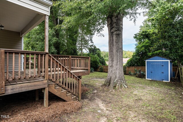 view of yard featuring a deck and a storage shed