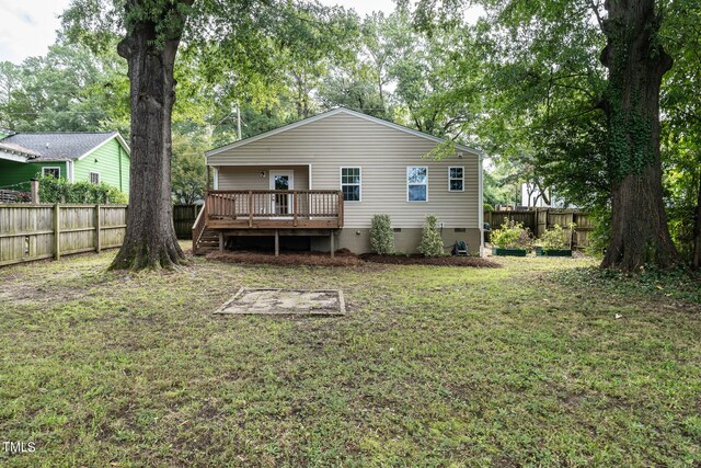 back of house featuring a yard and a deck