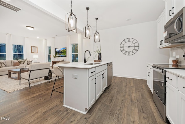 kitchen with a kitchen island with sink, sink, white cabinets, and stainless steel appliances