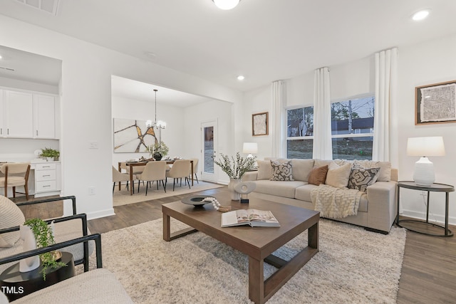 living room with dark hardwood / wood-style flooring and a notable chandelier