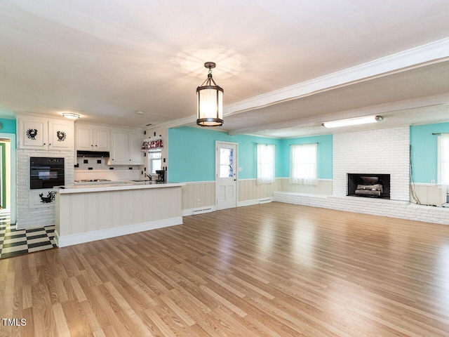 unfurnished living room featuring light hardwood / wood-style flooring, a fireplace, and sink