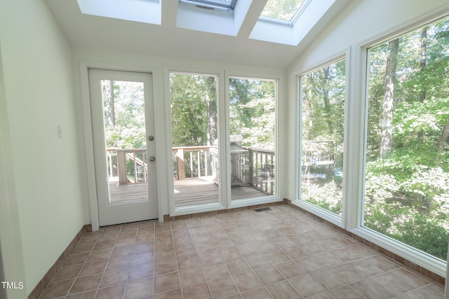 unfurnished sunroom featuring lofted ceiling with skylight and a healthy amount of sunlight