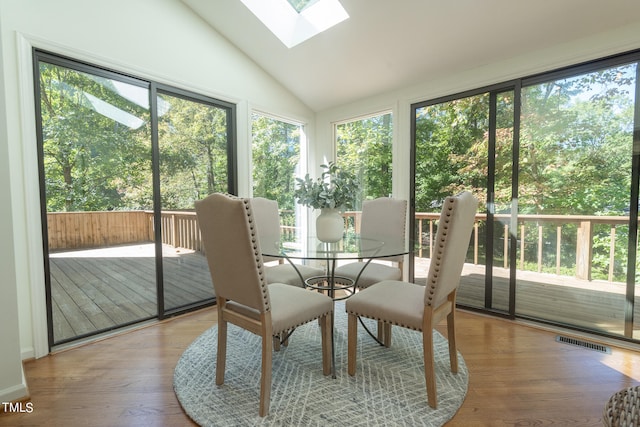 sunroom with vaulted ceiling with skylight and a healthy amount of sunlight