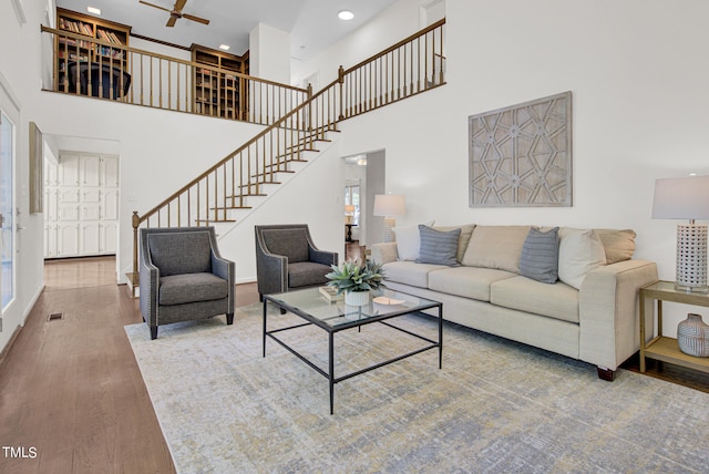 living room featuring a high ceiling, hardwood / wood-style floors, and ceiling fan