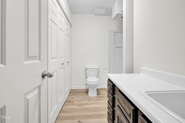 bathroom with hardwood / wood-style flooring, vanity, and toilet