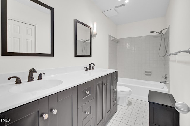 full bathroom featuring tile patterned floors, toilet, vanity, and tiled shower / bath combo