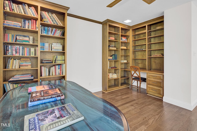 interior space with ceiling fan, dark hardwood / wood-style floors, crown molding, and built in desk