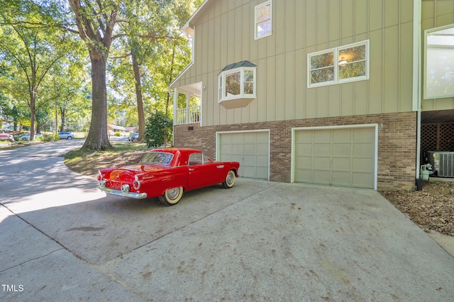 view of side of home with cooling unit and a garage