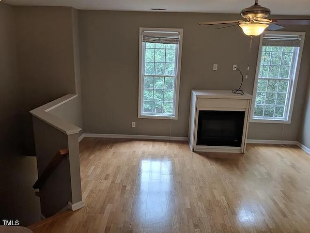 unfurnished living room featuring ceiling fan and light hardwood / wood-style flooring